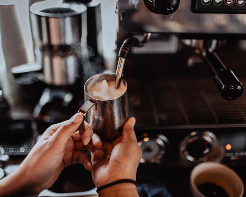 barista holding a milk pitcher