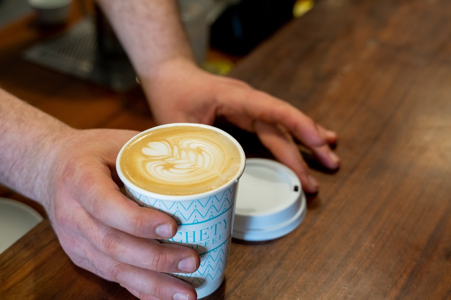 a barista serves a latte