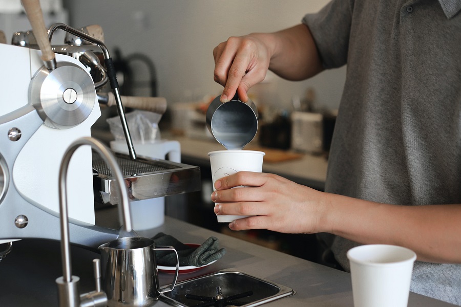 Barista pours milk for a latte