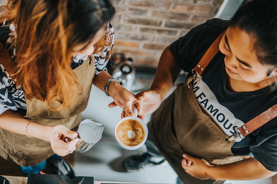 Two baristas serve coffee