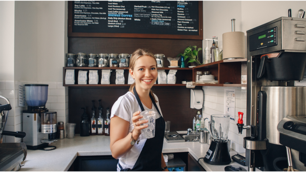 a barista serves coffee to a customer.